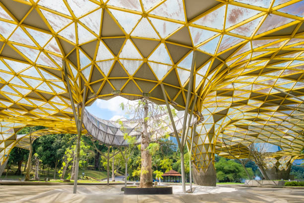 istock Perdana Botanical Garden, Kuala Lumpur, Malaysia with geometric yellow structure with a tree in the center, creating a blend of nature and modern architecture in an open park space in Asia 2189025904