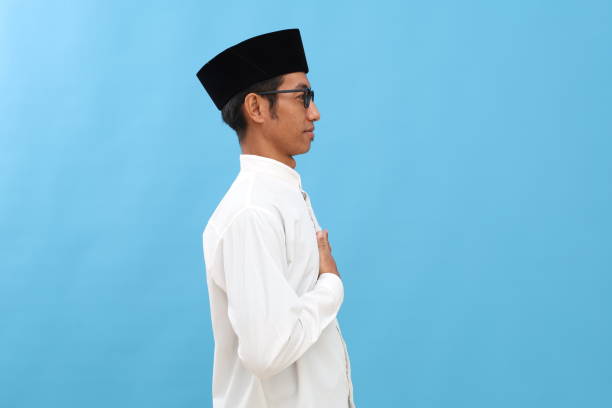 istock Young asian man wearing typical arab clothes isolated on blue background gazing left, sideways pose. 2189026715