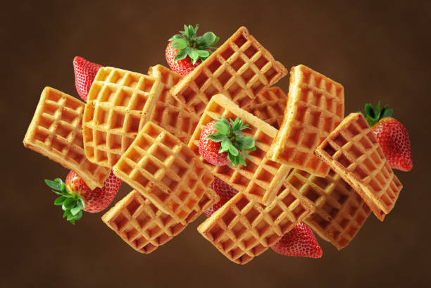 istock Belgian waffles with fresh strawberries in motion. 2189030766
