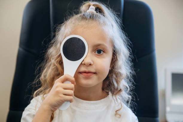 istock Session of testing the sight sharpness. Little girl is checking vision in the ophthalmologist cabinet 2189031162