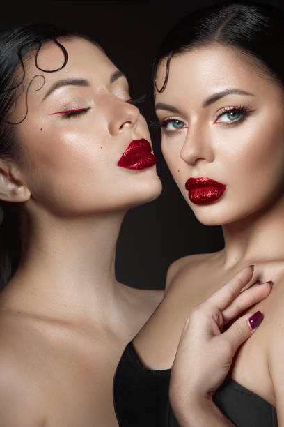 istock Two models showcase stunning beauty looks with vibrant red lips and captivating eye makeup. elegant lighting enhances their features, creating a dramatic and alluring atmosphere 2189032295