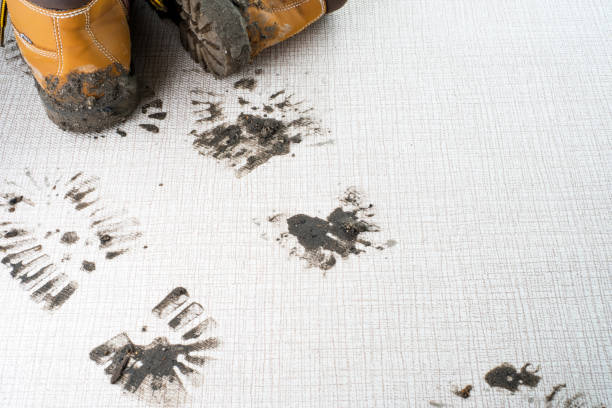 Dirty boots leave muddy footprints on a carpet