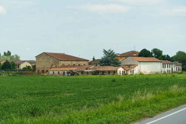 istock A tranquil countryside view featuring rustic buildings and a vibrant green field under a clear sky in rural Italy during the summer 2189035380