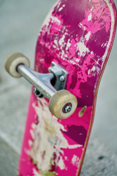 istock Used pink skateboard against stone wall in urban setting 2189035438