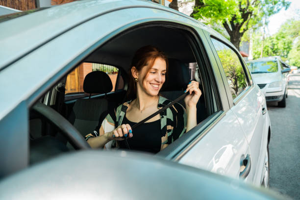 istock Young woman putting seat belt inside car 2189035806