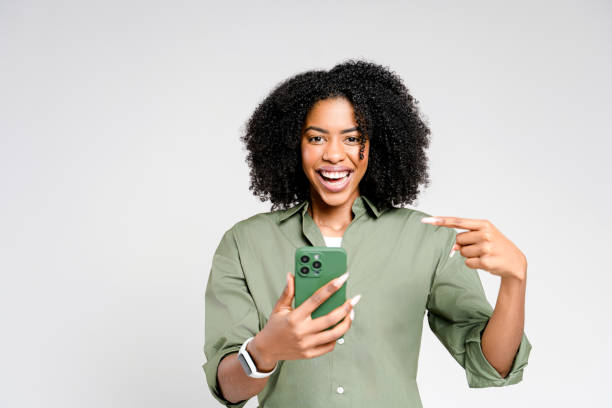 istock The woman points at her smartphone screen with a playful expression 2189036365