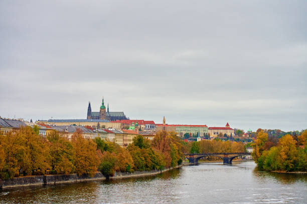 Cityscape of Prague with colorful autumn trees on island on Vltava river. Architecture of Praha, Czech Republic