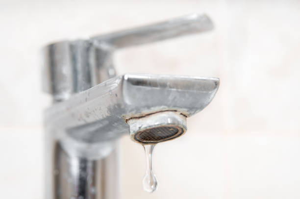istock Water drop close up dripping from dirty faucet with limescale 2189037397