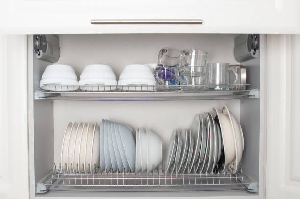 istock Clean  dishes, mugs and different glasses  in opened white kitchen cupboard shelf 2189037677