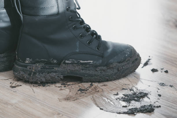 istock Boots covered in mud leave a trail on wooden floor 2189037982