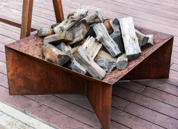 istock Rustic fire pit setup with layered firewood in a metal frame, placed on a wooden deck, warm and inviting atmosphere for camping, backyard leisure, or outdoor entertaining 2189038209