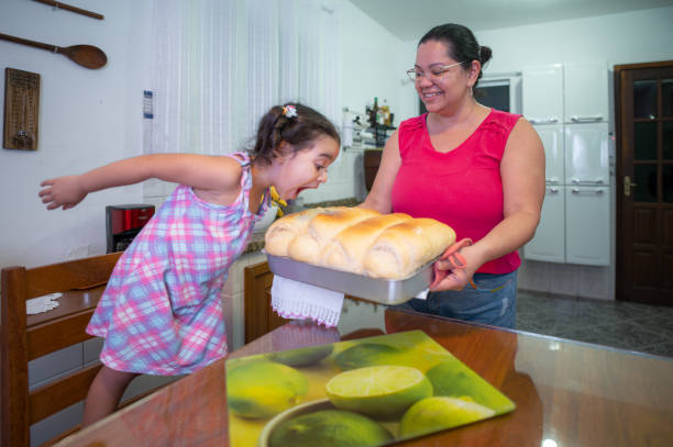 dad and child are breaking freshly baked white bread. family values concept