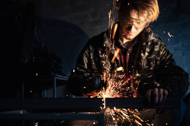 istock A man is working with metal using an angle grinder, with sparks flying around. 2189048403