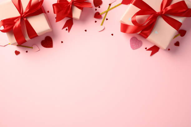 istock Happy Valentines Day concept. Flat lay gift boxes with red ribbons on a pink background, surrounded by glitter hearts, Cupid's arrows and confetti. 2189049155
