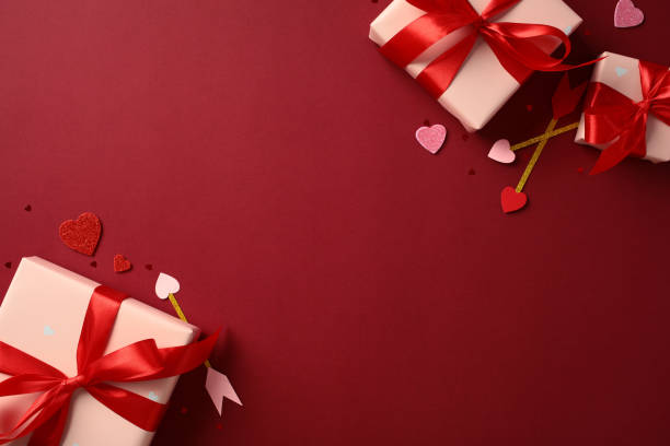 istock Happy Valentines Day concept. Gift boxes with red ribbons on a red background, surrounded by heart-shaped decorations and Cupid's arrows. Flat lay, top view, copy space. 2189049294