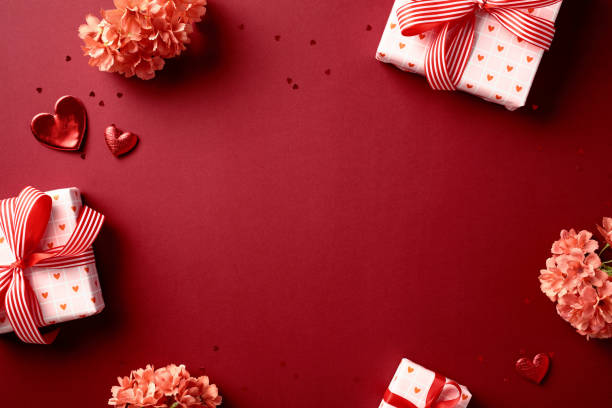 istock Valentine's Day flat lay with heart-patterned gift boxes, red heart decorations, and pink flowers on red background. Perfect for romantic and festive occasions 2189050379