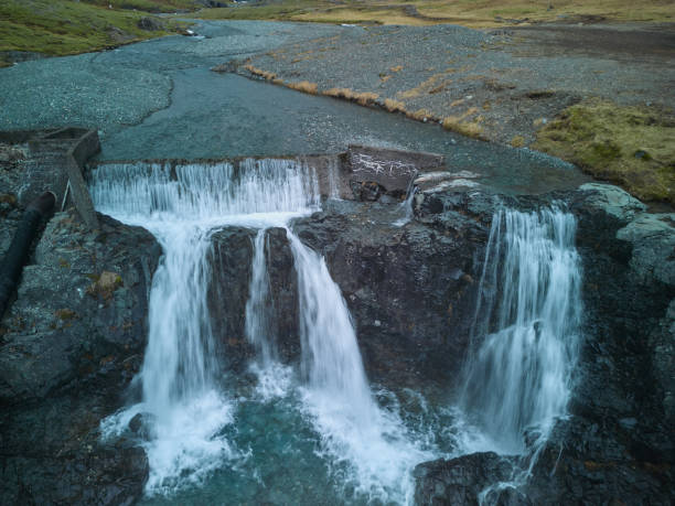 Water is cascading down small waterfalls in a mountain river, creating a beautiful natural scene