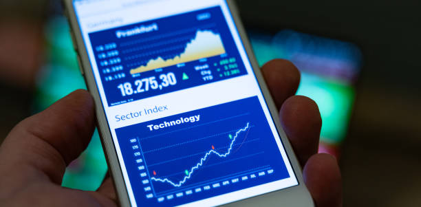 istock Hand holds a smartphone which shows a rising technology stock index. 2189051796
