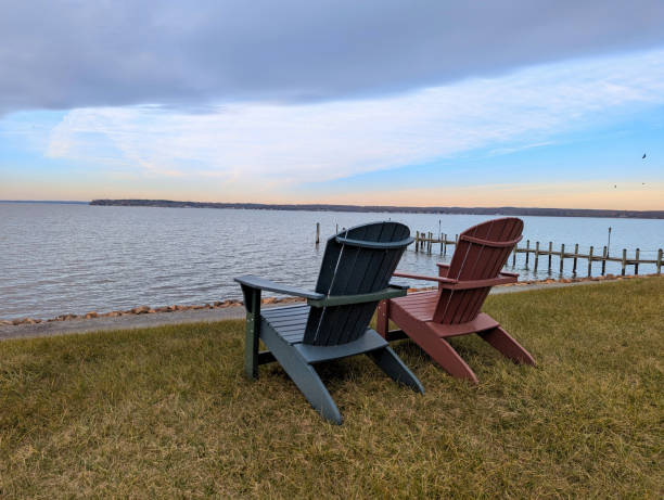 istock Empty chairs overlooking a calm body of water 2189053773