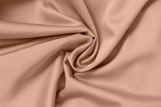 istock Twisted beige satin fabric forming elegant folds and smooth texture 2189054641