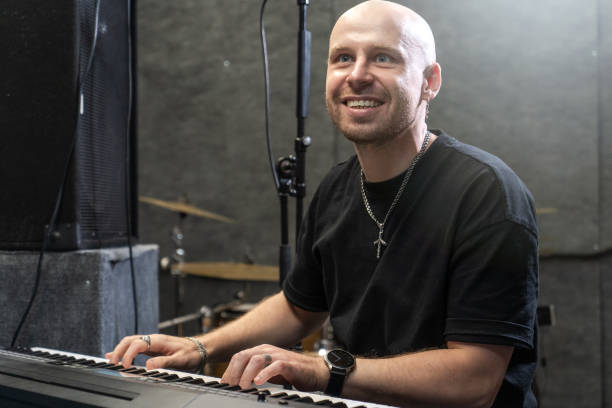 istock Bald male musician playing keyboard in studio, smiling with joy 2189058224