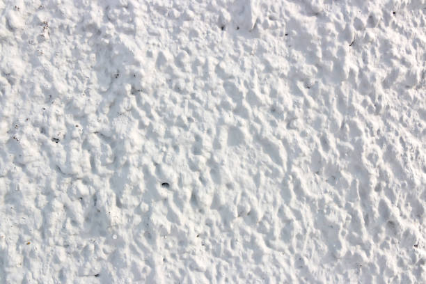 Texture of white concrete wall with cracks and scratches which can be used as a background