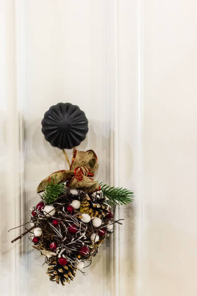 Festive Christmas door decor featuring pine cones, greenery, and ribbons adds a seasonal touch to home decor and creates a welcoming holiday atmosphere.