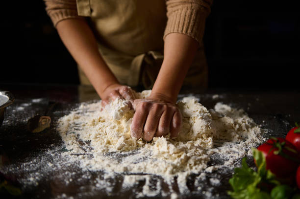 istock Baker kneading dough in a kitchen surrounded by fresh ingredients 2189059051