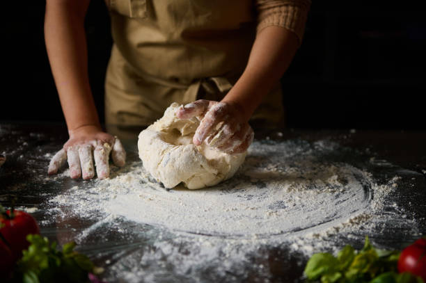 istock Person kneading dough on a floured surface in a kitchen setting 2189059851
