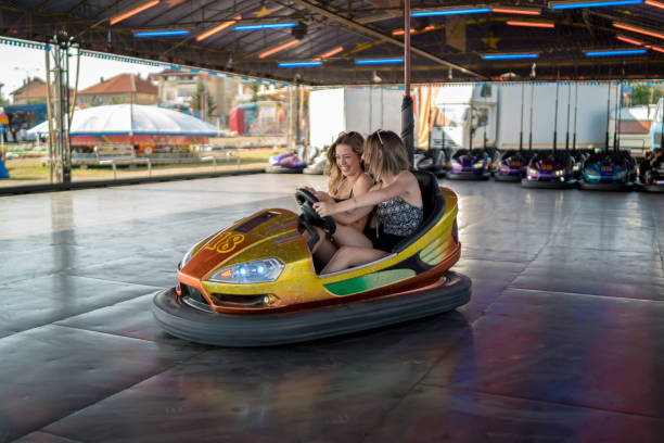 Happy girlfriends driving a bumper car and smiling