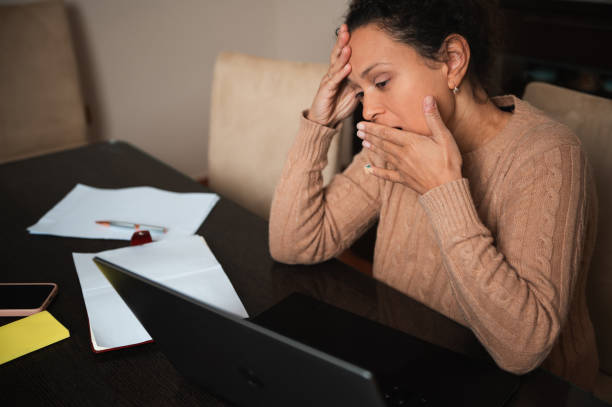 istock Stressed woman at home office with laptop and paperwork on table 2189061988