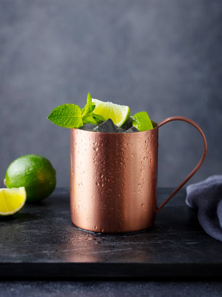 istock Moscow mule cocktail in copper mug with fresh mint, lime on marble board. Dark background. Copy space. 2189062830