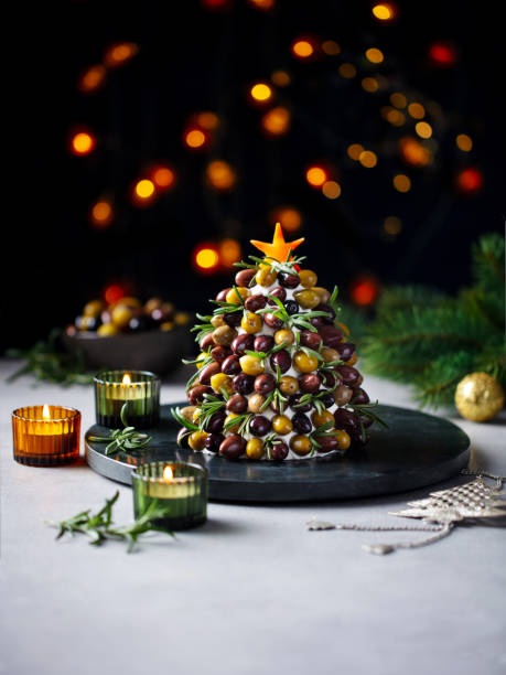 Christmas olives, cream cheese tree, creative side dish, table decoration. Copy space. Dark background.
