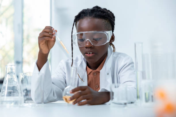 istock Smiling female researcher with petri dish and flasks analyzing chemical liquid in laboratory 2189063283