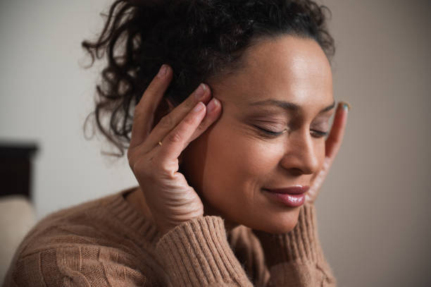 Woman relaxing with eyes closed and hands on her temples