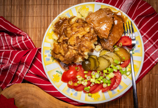 Stewed pork in its own sauce served with mashed potatoes, tomato and pickled cucumber.