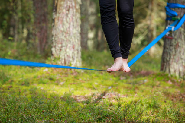 istock Close-up of feet balancing on a slackline in a lush forest setting 2189064302