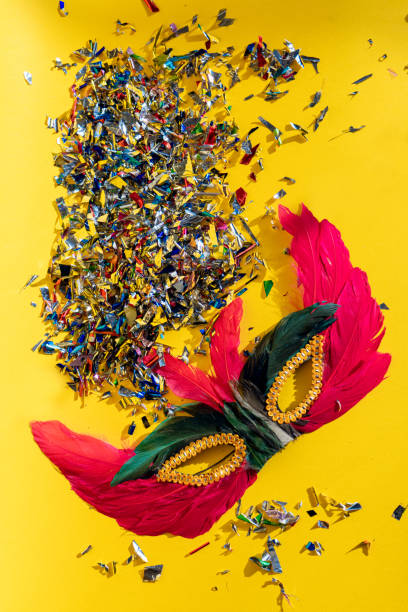 Carnival mask, beautiful carnival mask under reflective surface surrounded by confetti and streamer, selective focus.