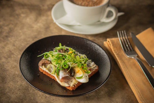 istock Close-up of a rustic toast topped with herring, boiled egg, greens 2189066815