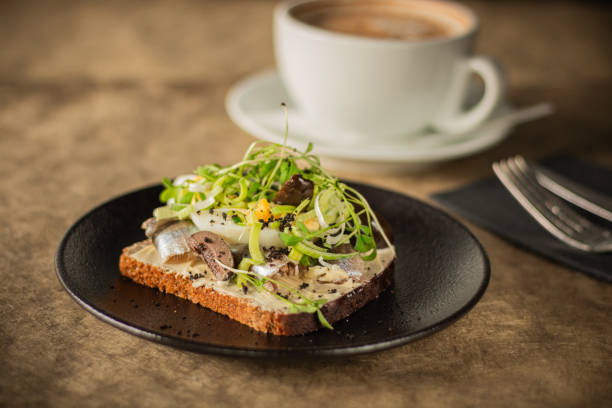 istock Close-up of a rustic toast topped with herring, boiled egg, greens 2189067542