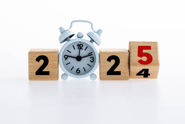 istock Turned a wooden cube and changed number 2024 to 2025 with small white alarm clock 2189067566