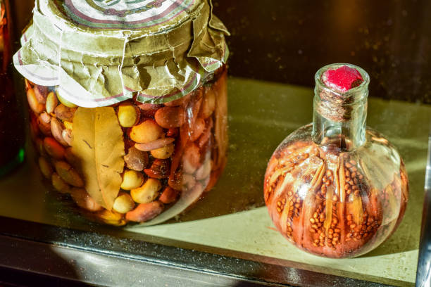 Sunny windowsill still life with a large jar of olives and a glass bottle of pickled peppers