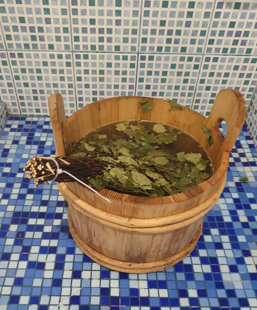 Wooden bath bucket with water and birch broom, everything for a bath