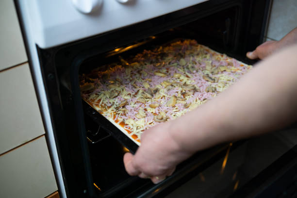 istock Woman's hands putting homemade pizza in the oven 2189069931