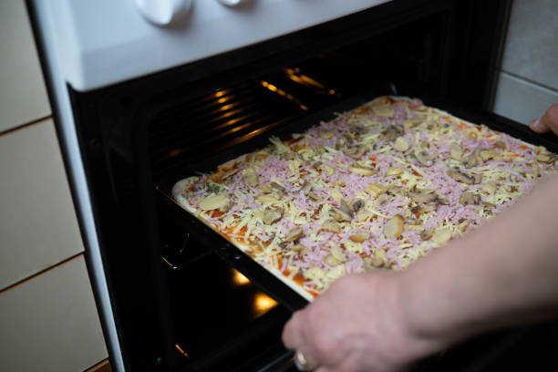 istock Woman's hands putting homemade pizza in the oven 2189069952