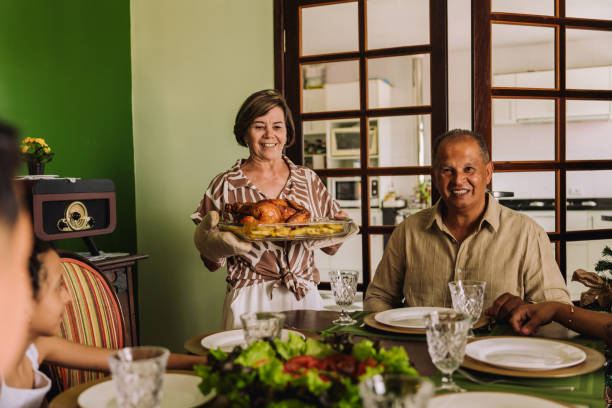 Latin family sitting at the table, celebrating Christmas, having dinner