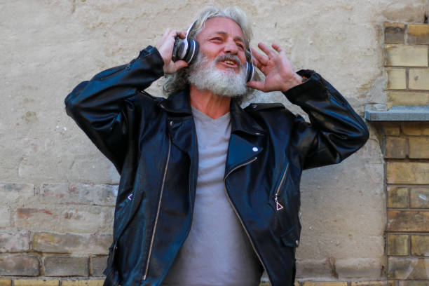 using skateboard relax active senior beard long hair rocker leather jacket retro happy positive emotions listen music