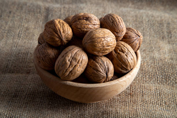 istock Bowl full of shelled walnuts on burlap sack,top view 2189072085