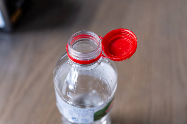 istock PET bottle with a new design where the red plastic cap remains attached after opening, facilitating easier collection and recycling of the entire package 2189072266