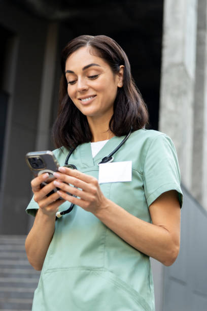 istock Young female doctor in a lab coat with a phone in hands 2189072622